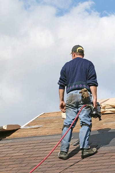 roofer-looking-at-shingles-while-holding-a-power-tool-picture-id172260573.jpeg